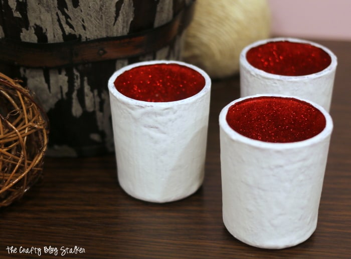 Painted Glass Votive Candle holders that are red on the inside and white on the outside.