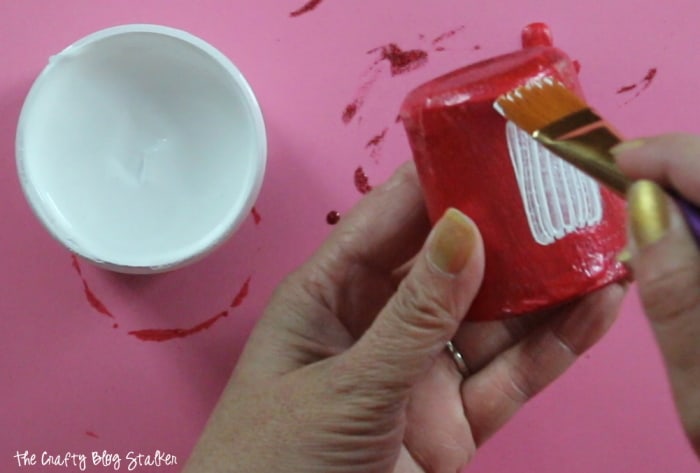 painting gesso onto the outside of a candle holder