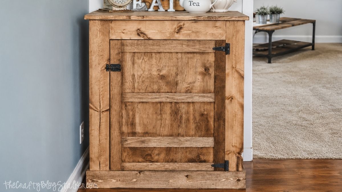 Rustic wooden cabinet with barn door hardware and farmhouse decor displayed in a cozy home interior.