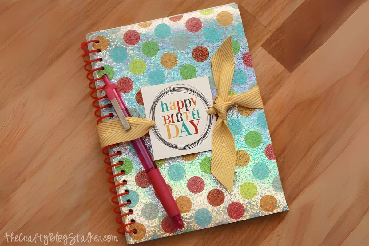 Birthday gift of a notebook and pen with a printable gift tag.