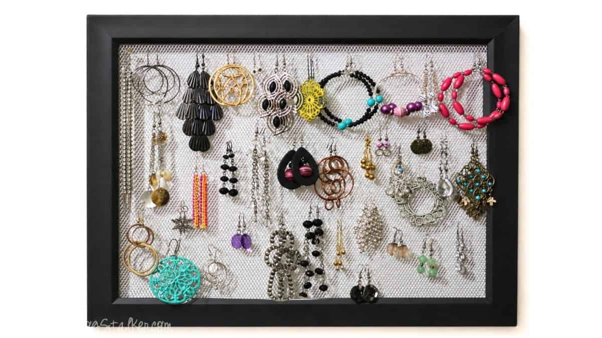 Handmade earring holder frame filled with earrings.