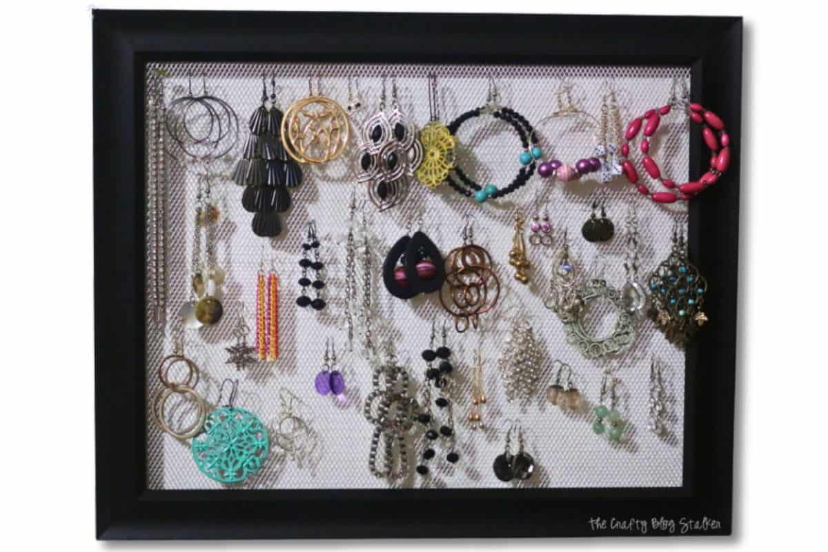 Handmade earring holder frame filled with earrings.