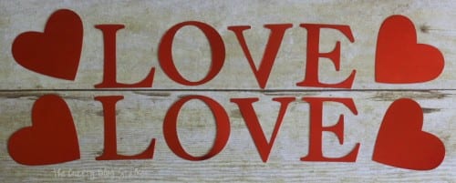 the word love cut out of red foil card stock with a big shot