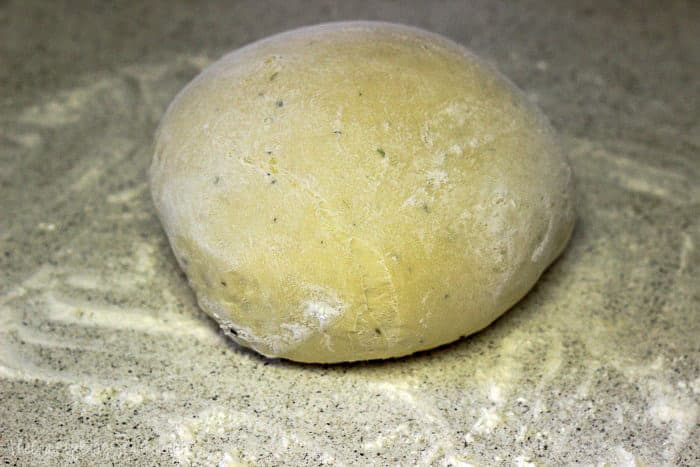 Ball of flour dough on a floured surface.