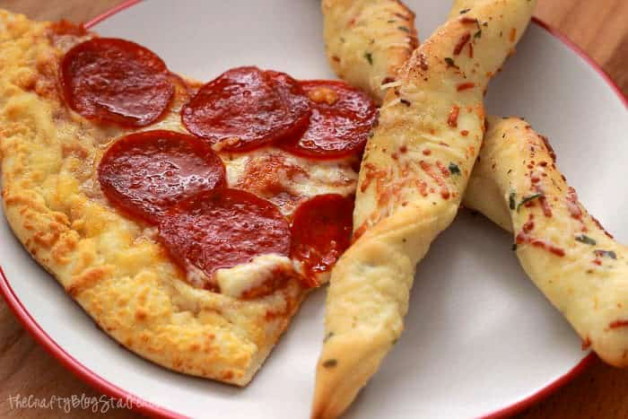Garlic Parmesan Breadsticks  with a slice of pizza.