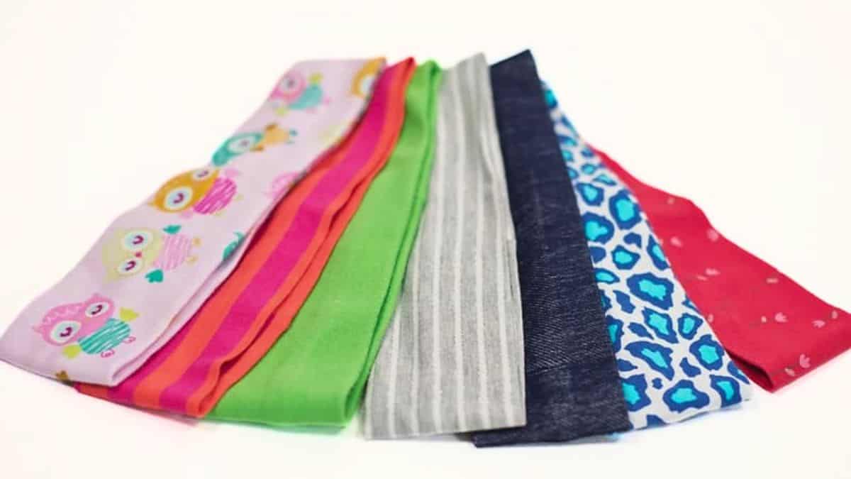 Colorful stretchy fabric headbands in assorted prints and solid colors fanned out on a white background.