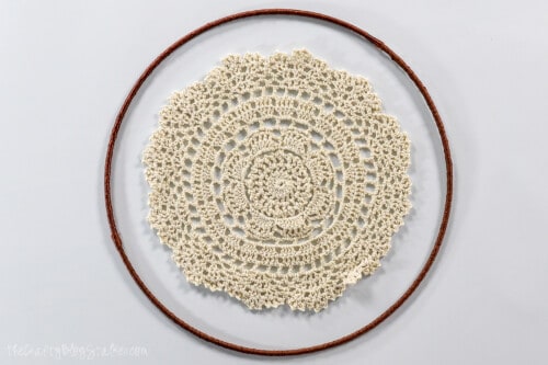 a crocheted doily in the center of a ring