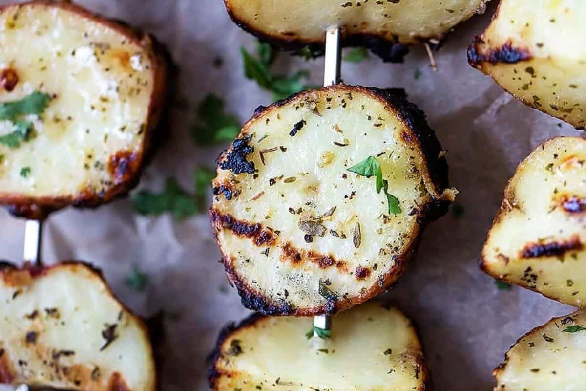 Grilled ranch-seasoned potato slices on skewers, charred to perfection and garnished with fresh herbs for a simple and flavorful side dish.