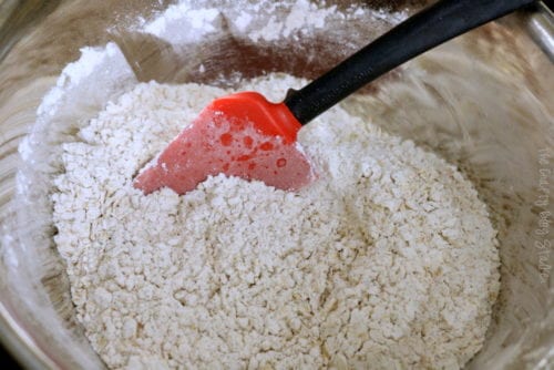 stirring the dry ingredients with a red spatula