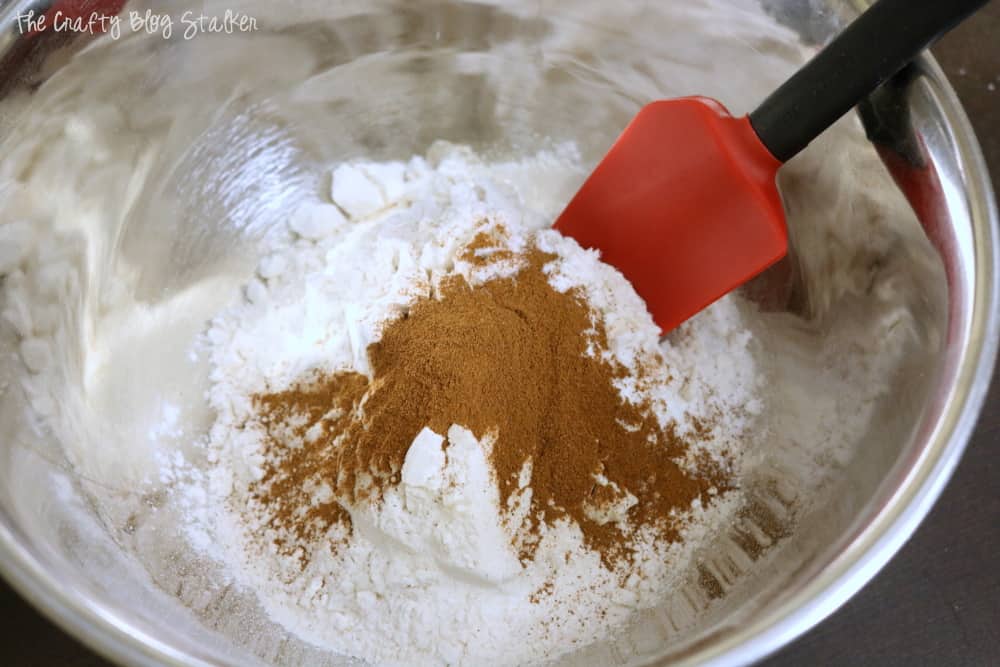 In a large bowl stir together with a spoon the flour, baking soda, salt, and cinnamon. 