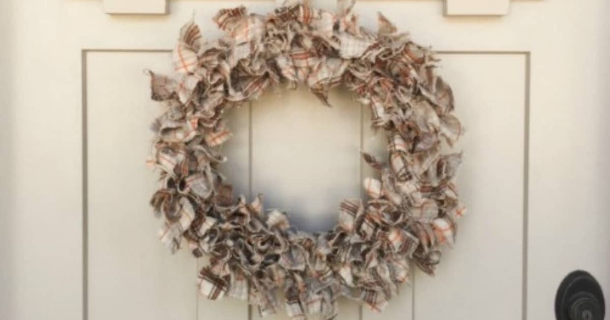 Fall fabric rag wreath hanging on a white door.