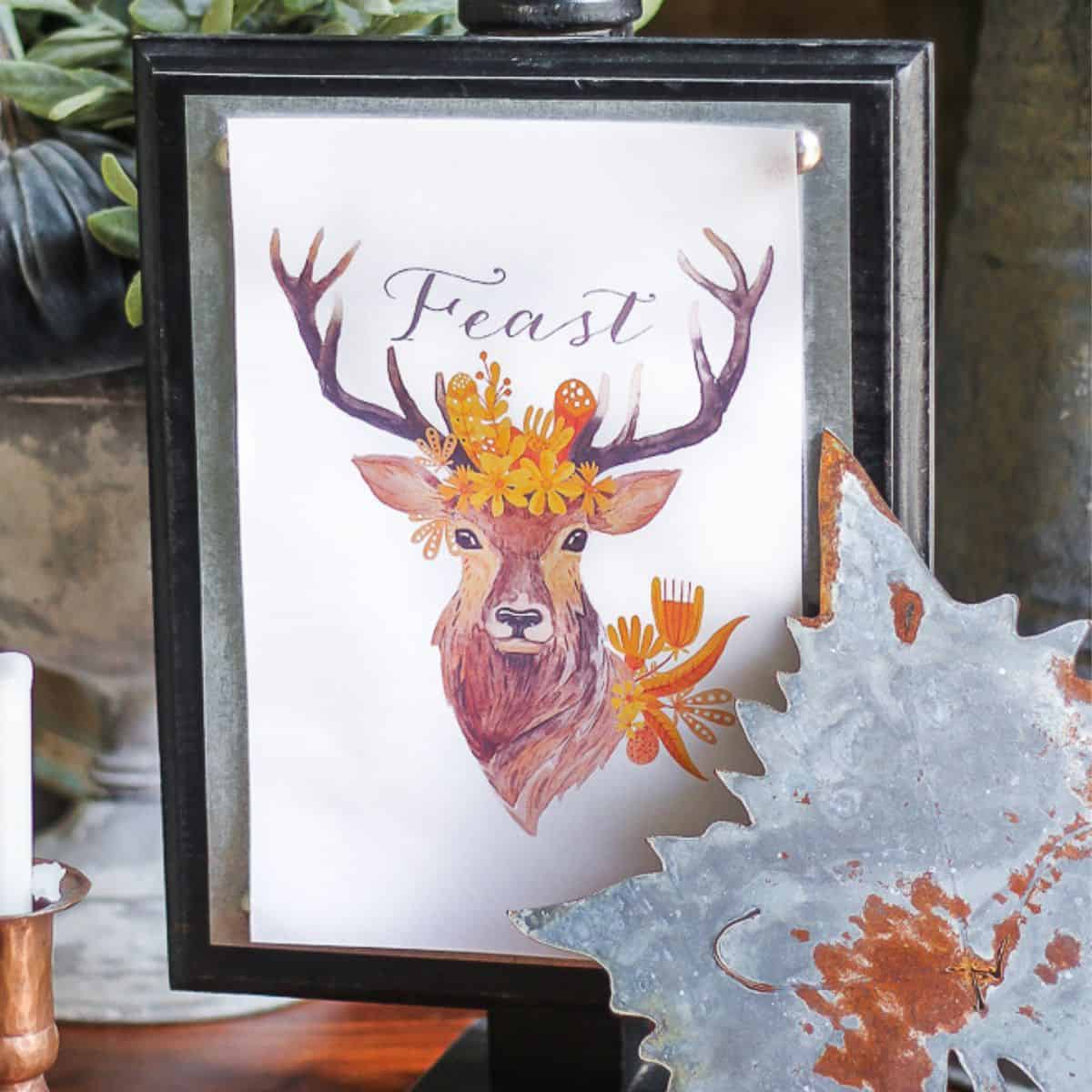 Framed fall printable featuring a watercolor deer with antlers, orange flowers, and the word