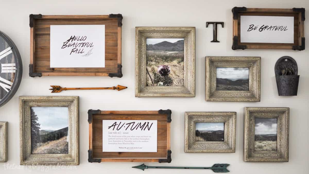 Looking for easy Fall Decor? This Autumn Definition Printable along with over 35 more is the perfect way to easily add a little Fall Decor to your home. Gallery wall with framed fall printables, rustic landscape photos, decorative arrows, and vintage-style accents.