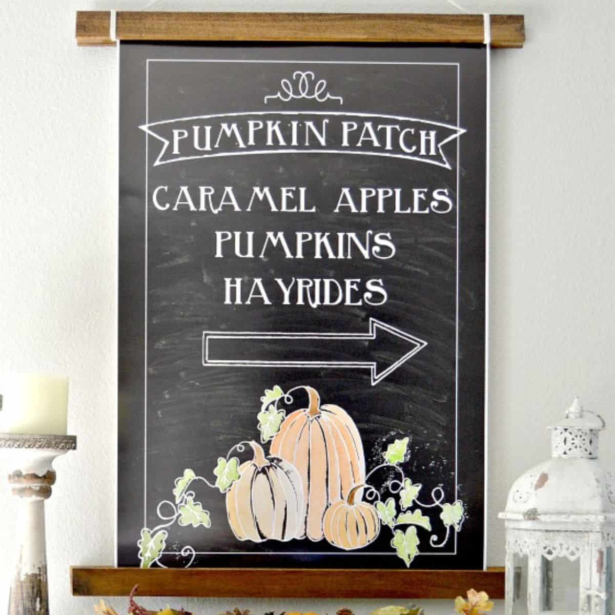 Fall mantel display with a chalkboard pumpkin patch sign, pumpkins, pinecones, candles, and a white lantern arranged above a bookshelf.