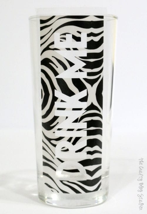 "drink me" stencil applied to the drinking glass