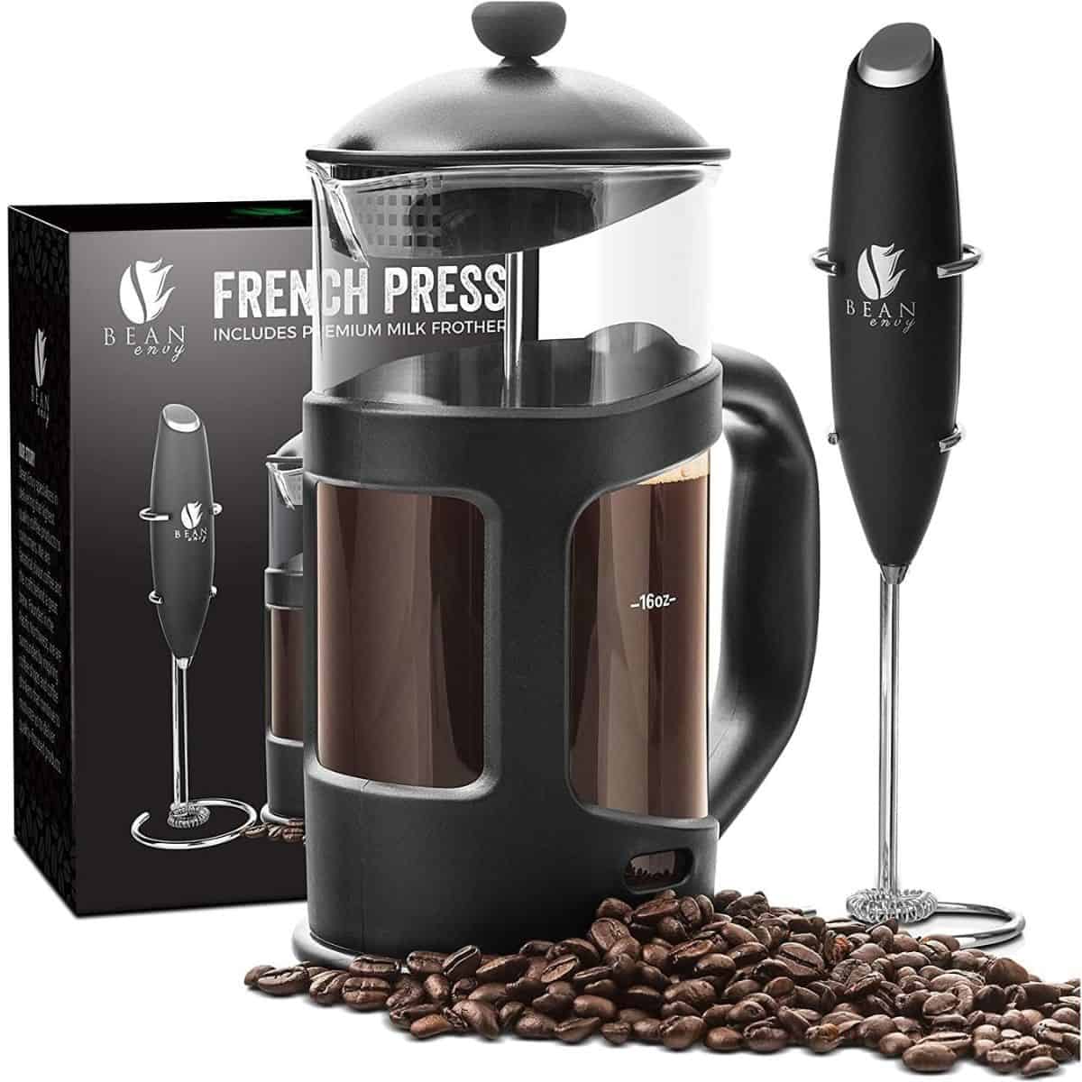 A Bean Envy French press coffee maker with a glass carafe, black frame, included milk frother, and coffee beans scattered at the base.