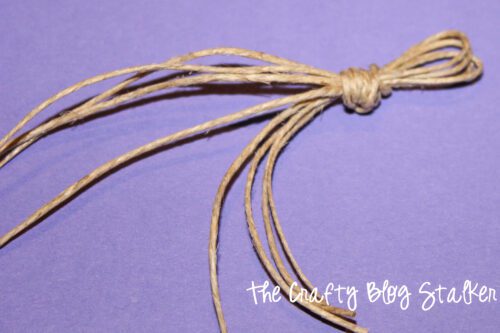 a knot tied in 4 strands of twine