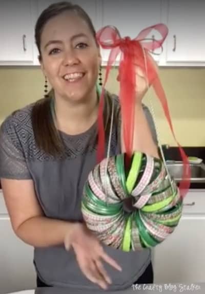 a woman holding the washi tape christmas wreath