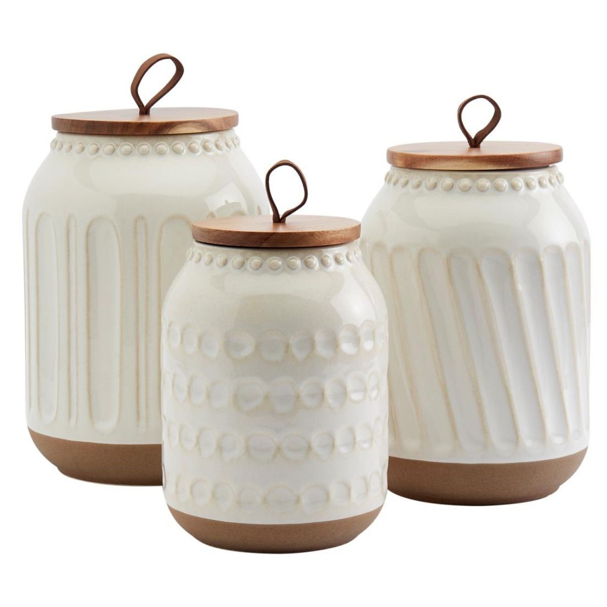 Three decorative kitchen canisters with textured ceramic bodies and wooden lids, arranged together for countertop storage.
