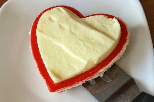 Moving the cheesecake heart to a plate with a spatula.