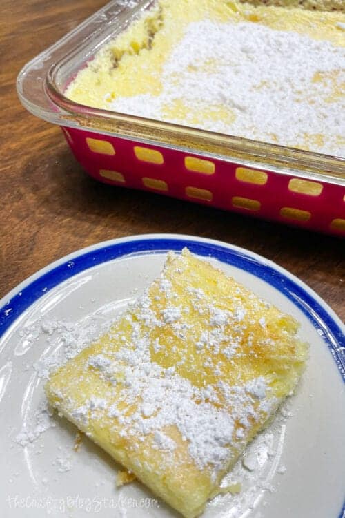 One serving of lemon bars on a white plate.