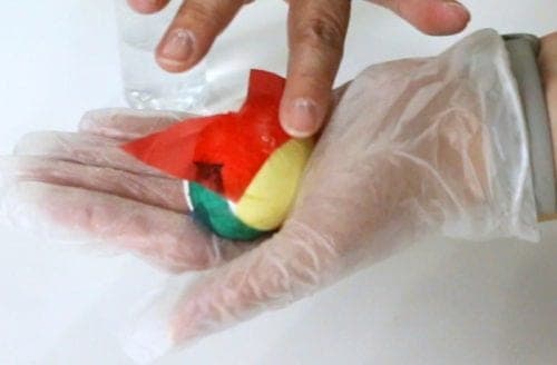 applying cut tissue paper pieces to a wet egg