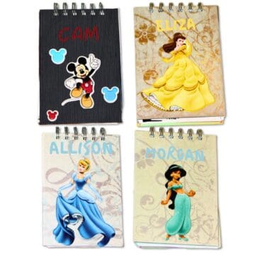 Four handmade Disney autograph books featuring Mickey Mouse, Belle, Cinderella, and Jasmine with personalized names on the covers.