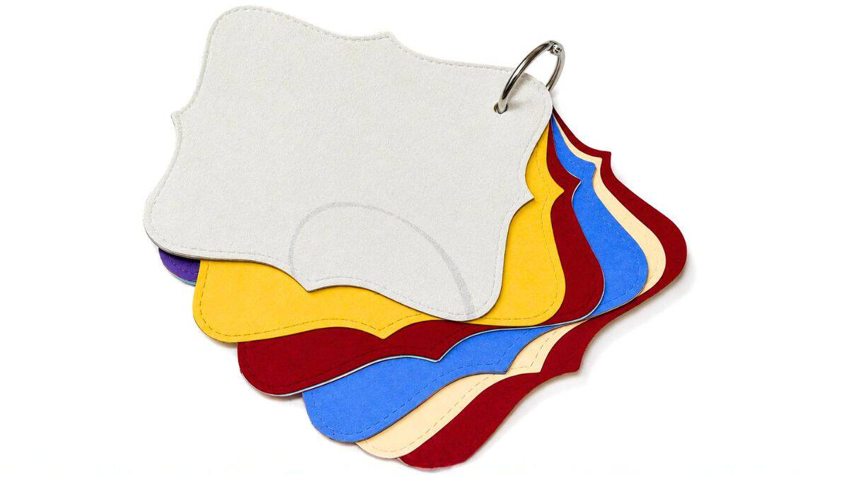 Stack of colorful shaped pages with rounded corners bound together by a metal ring for an autograph book.