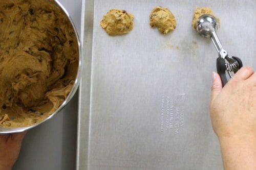 scooping to the cookie dough onto a baking sheet
