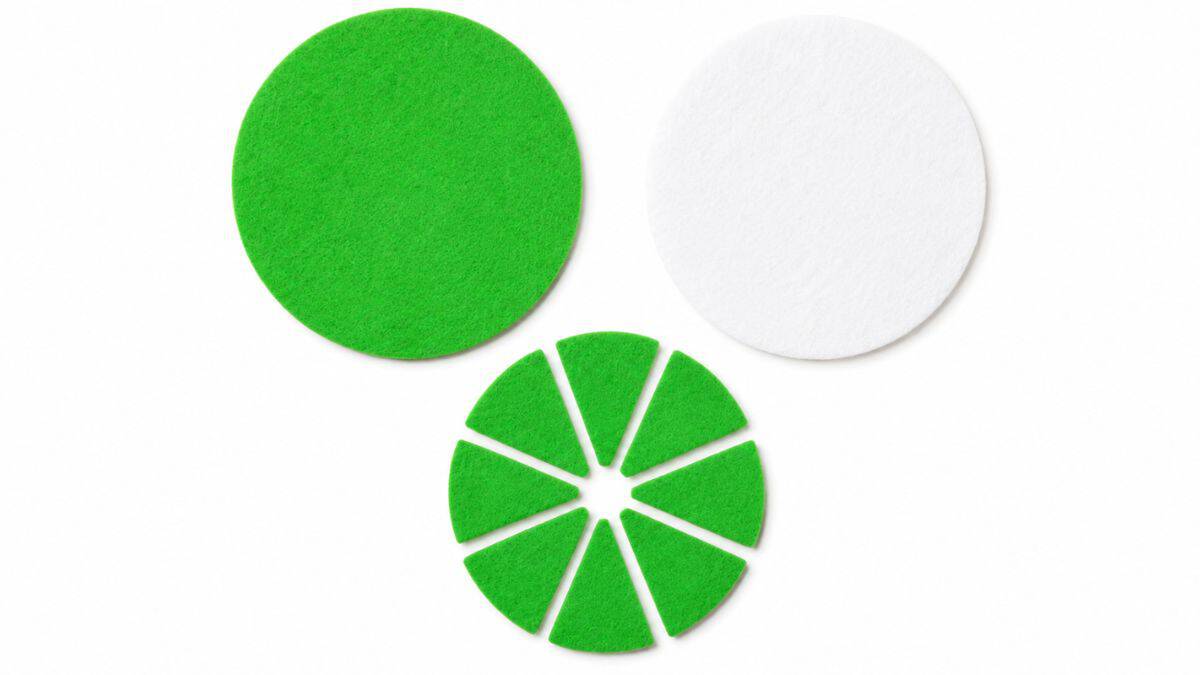 Green and white felt pieces cut into citrus slice shapes for DIY coasters, including a full circle base and segmented lime slices.