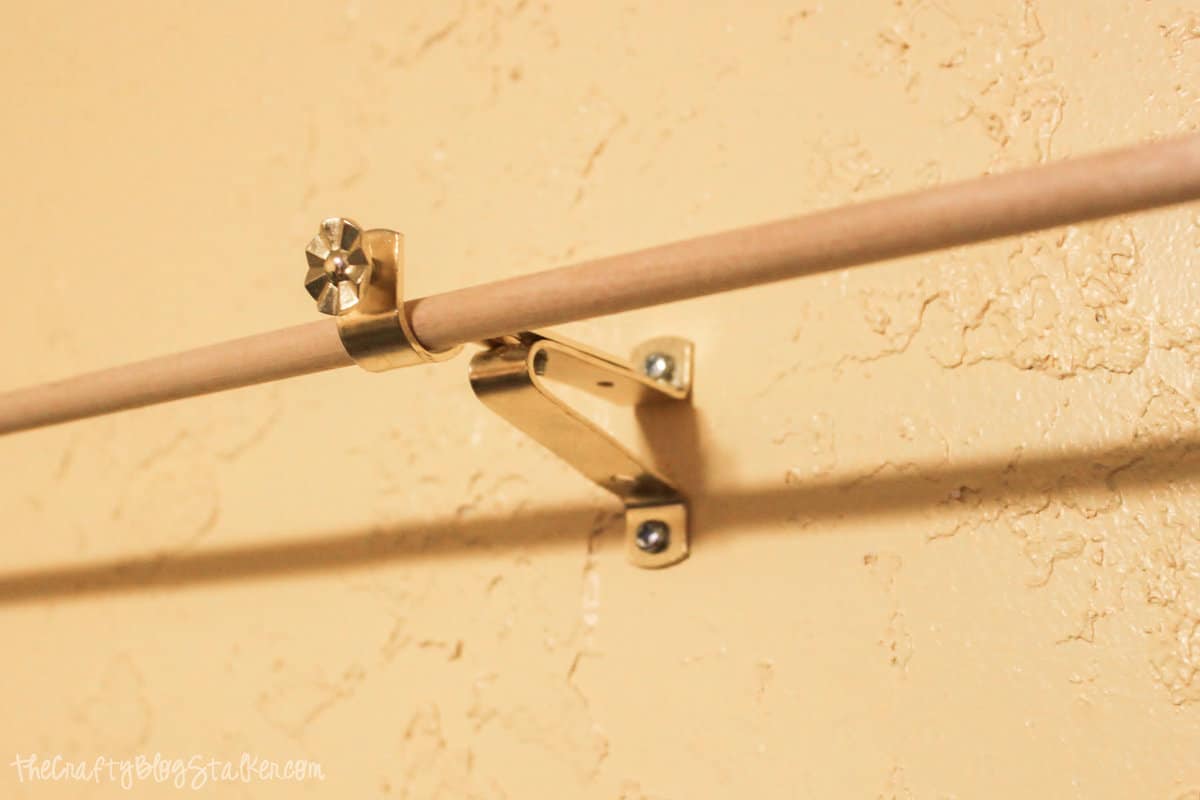 installing dowels to hold ribbon on a craft room wall