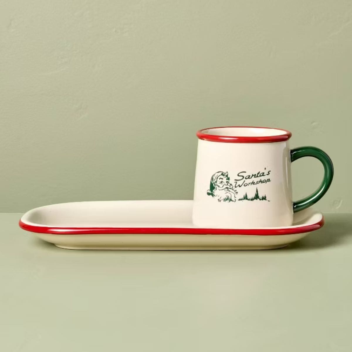 Cream-colored ceramic cookie plate and mug set with red trim, green handle, and