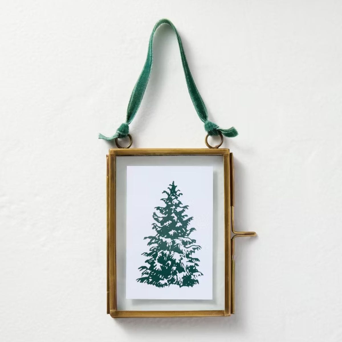 Gold rectangular glass ornament frame with a green velvet ribbon, displaying an image of a green Christmas tree on a white background.