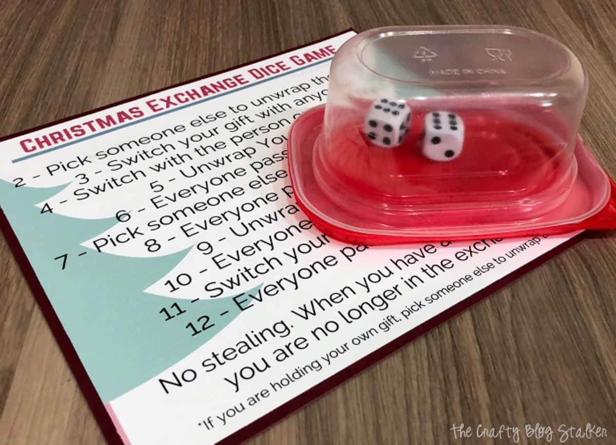 Christmas Dice Game rules and two dice in a Tupperware container. 