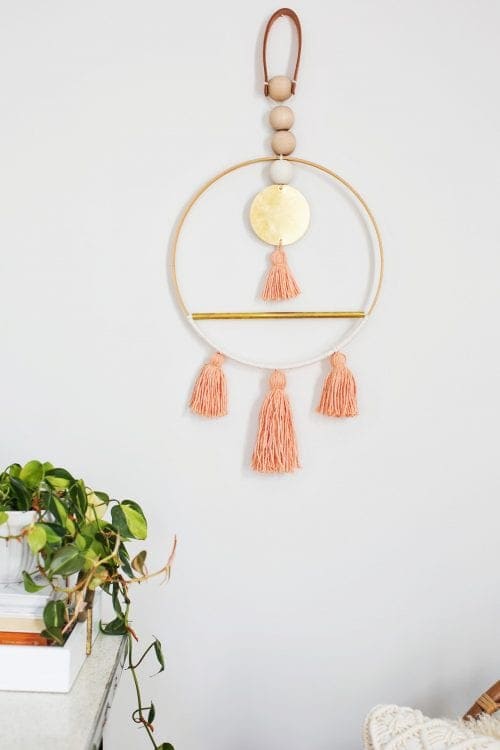 Scandinavian Wall Art in gold and coral hanging on a white wall.