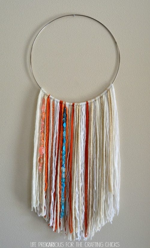 Easy DIY Wall Hanging made with different colored yarn and beads.