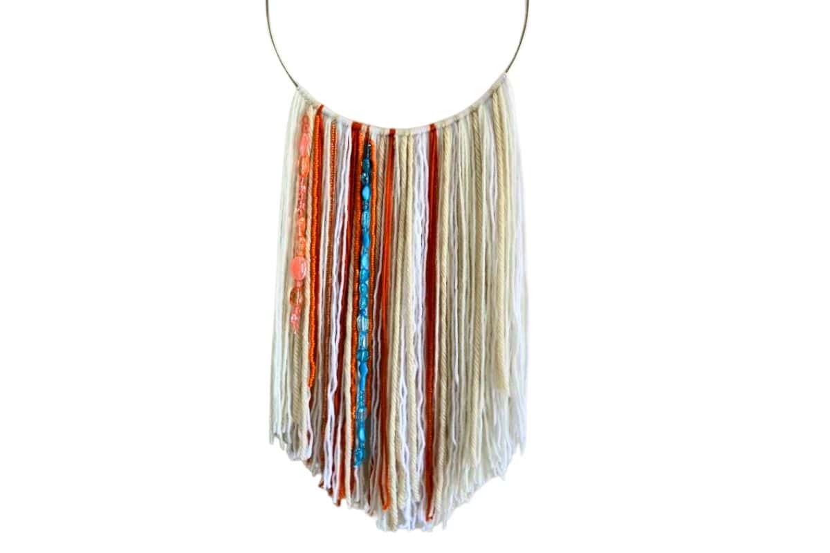 Easy DIY Wall Hanging made with different colored yarn and beads.