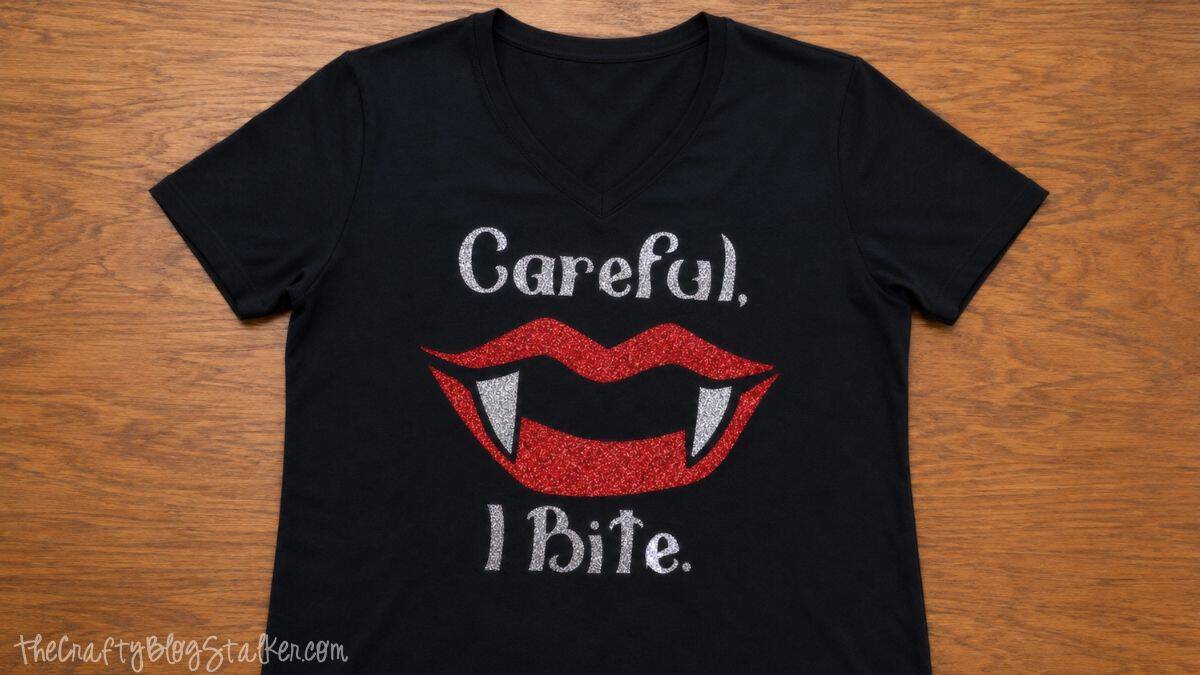Black V-neck Halloween T-shirt with red glitter vampire lips, silver fangs, and the words 