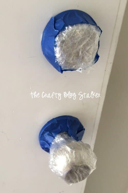 covering the doorknob and lock with plastic wrap and painter's tape
