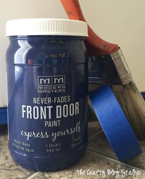 modern masters calm blue front door paint with paintbrush and painter's tape