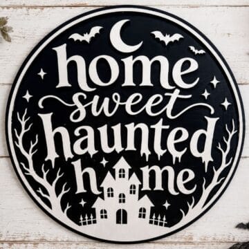 Black and white Home Sweet Haunted Home Halloween sign featuring a haunted house, bats, crescent moon, stars, and bare trees.