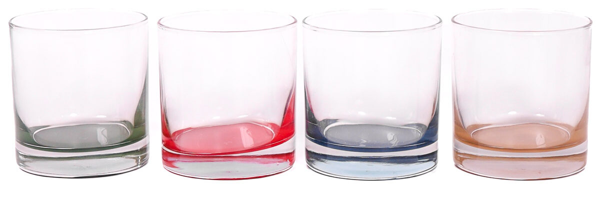 Set of four clear glasses with painted bottoms in green, red, blue, and tan arranged in a row on a white background.