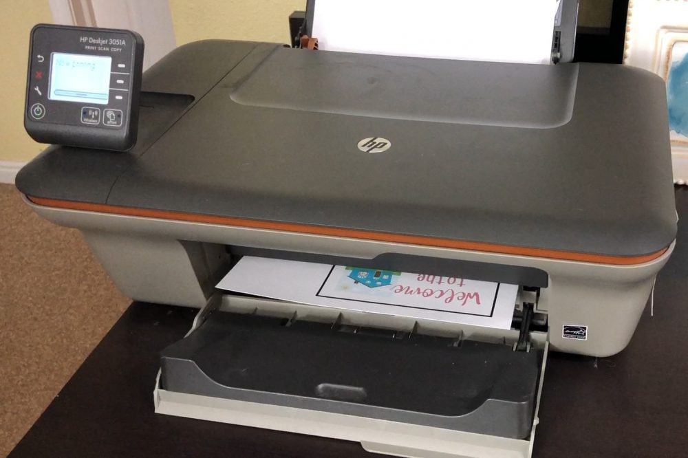 How to Print and Cut in Cricut Design Space by popular US craft blog, The Crafty Blog Stalker: image of a label being printed off in a Cricut machine. 