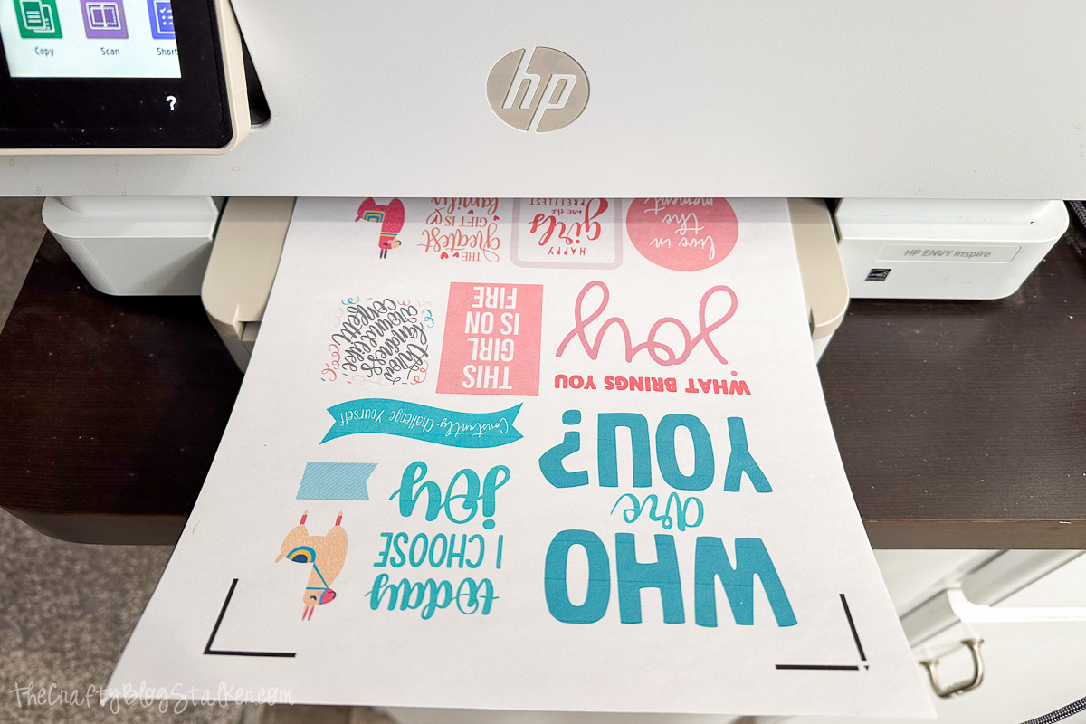 HP printer printing a sheet of colorful print and cut journaling stickers featuring motivational quotes, llamas, and decorative elements for a Cricut craft project.