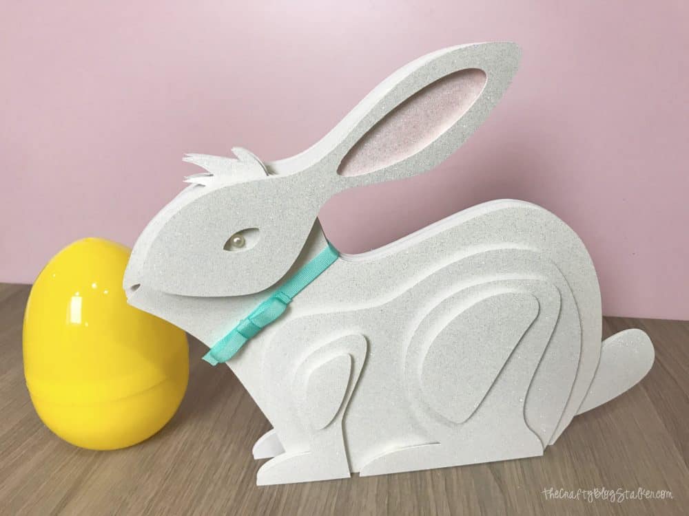 finished layered paper art bunny with a pink background with a yellow plastic easter egg