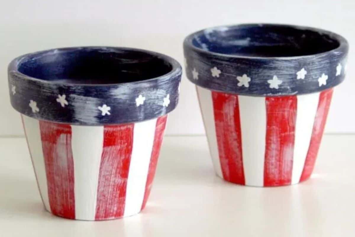 Two Terra Cotta Pots painted white, with red stripes and blue stars.
