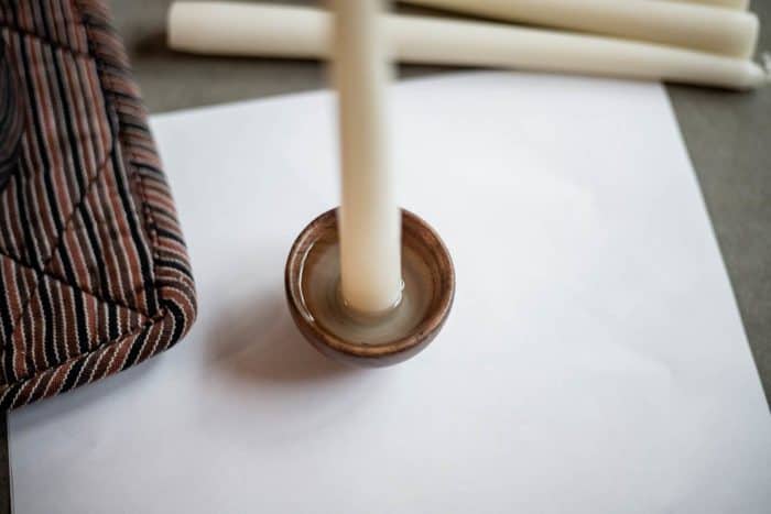 Pour melted wax in wooden bowl to hold candle in place. 