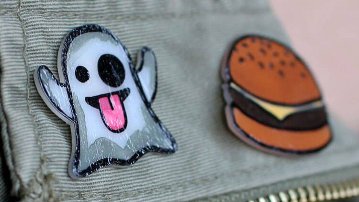 Close-up of a fabric pouch with a zipper, decorated with a cute ghost patch and a cheeseburger patch sewn onto the front.