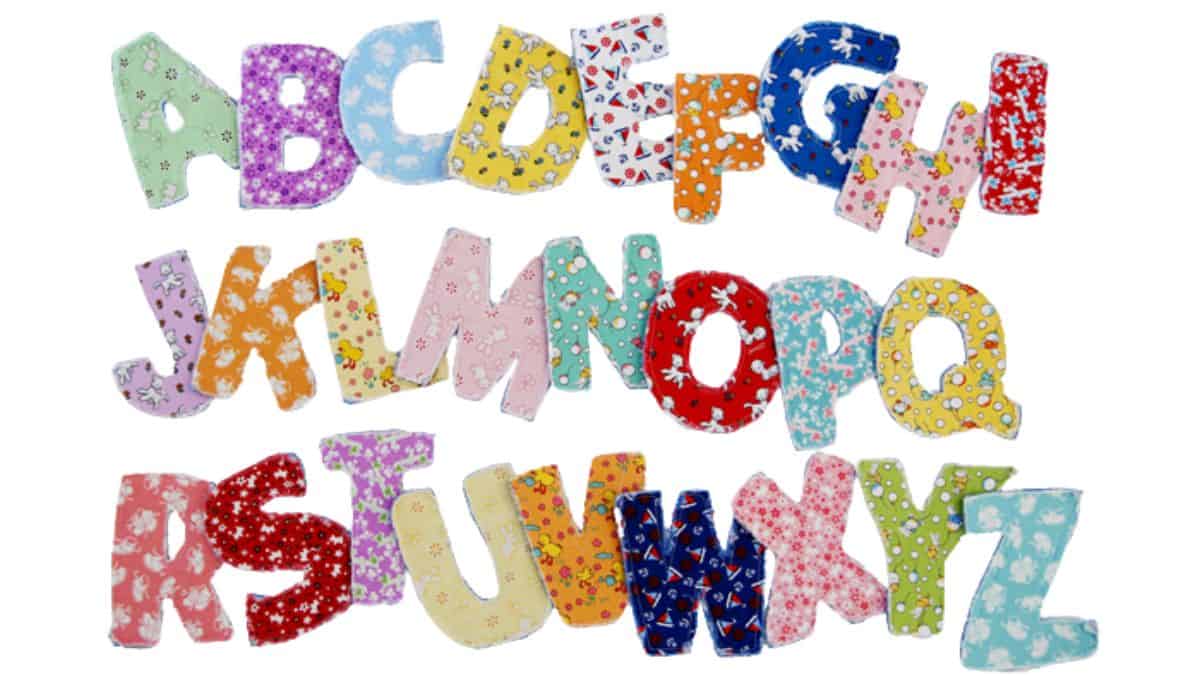 Handmade fabric alphabet letters A through Z, each sewn from patterned cotton fabric, arranged in rows on a white background.