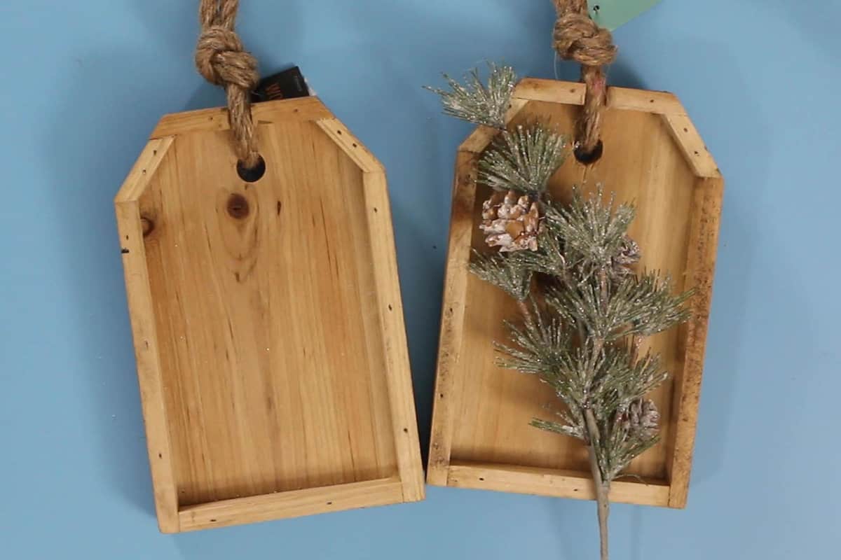 two wooden tags with a floral winter pine pick
